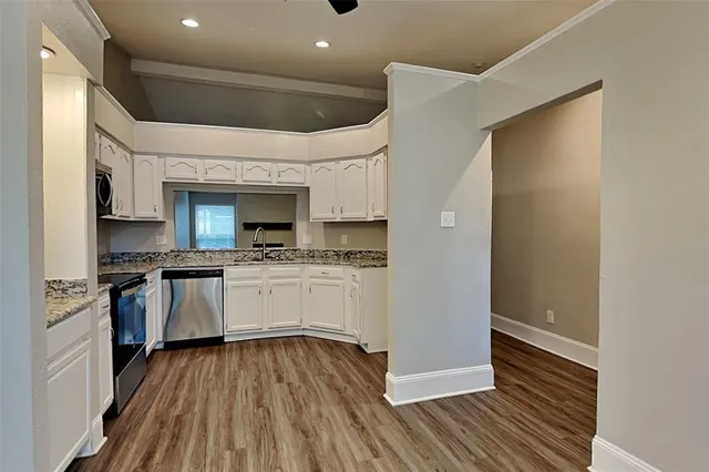 a kitchen with a refrigerator and white cabinets