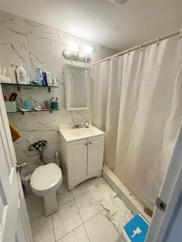 a bathroom with a sink a toilet and shower curtain