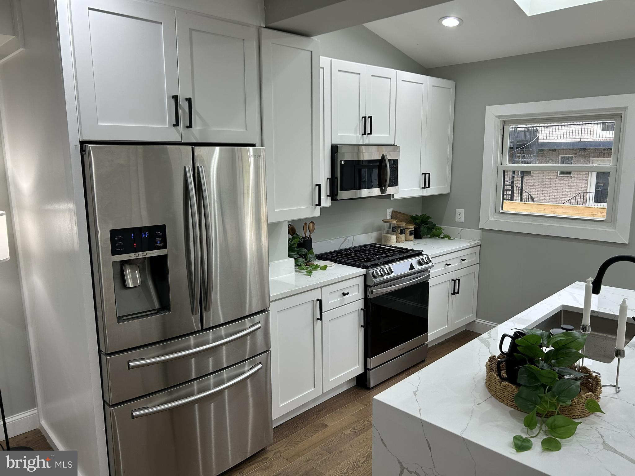928 Perry Place Northeast Washington, DC 20017 - Photo 5 of 16 a kitchen with white cabinets and stainless steel appliances