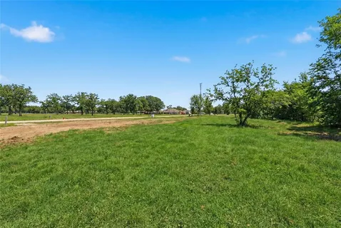a view of a green field with wooden fence