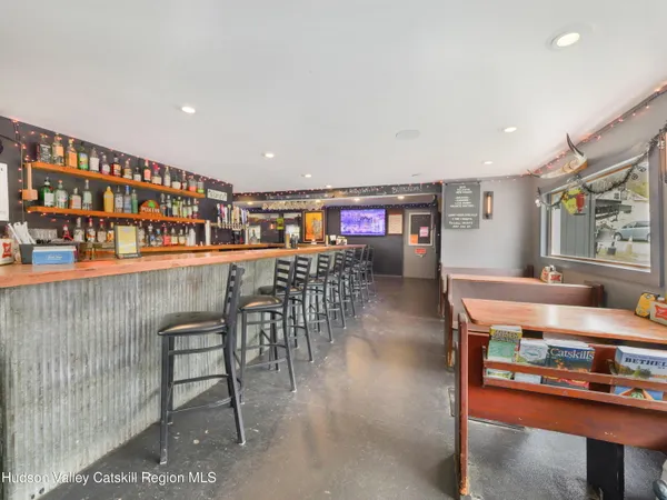 a dining hall with stainless steel appliances granite countertop a stove a sink a dining table and chairs with wooden floor