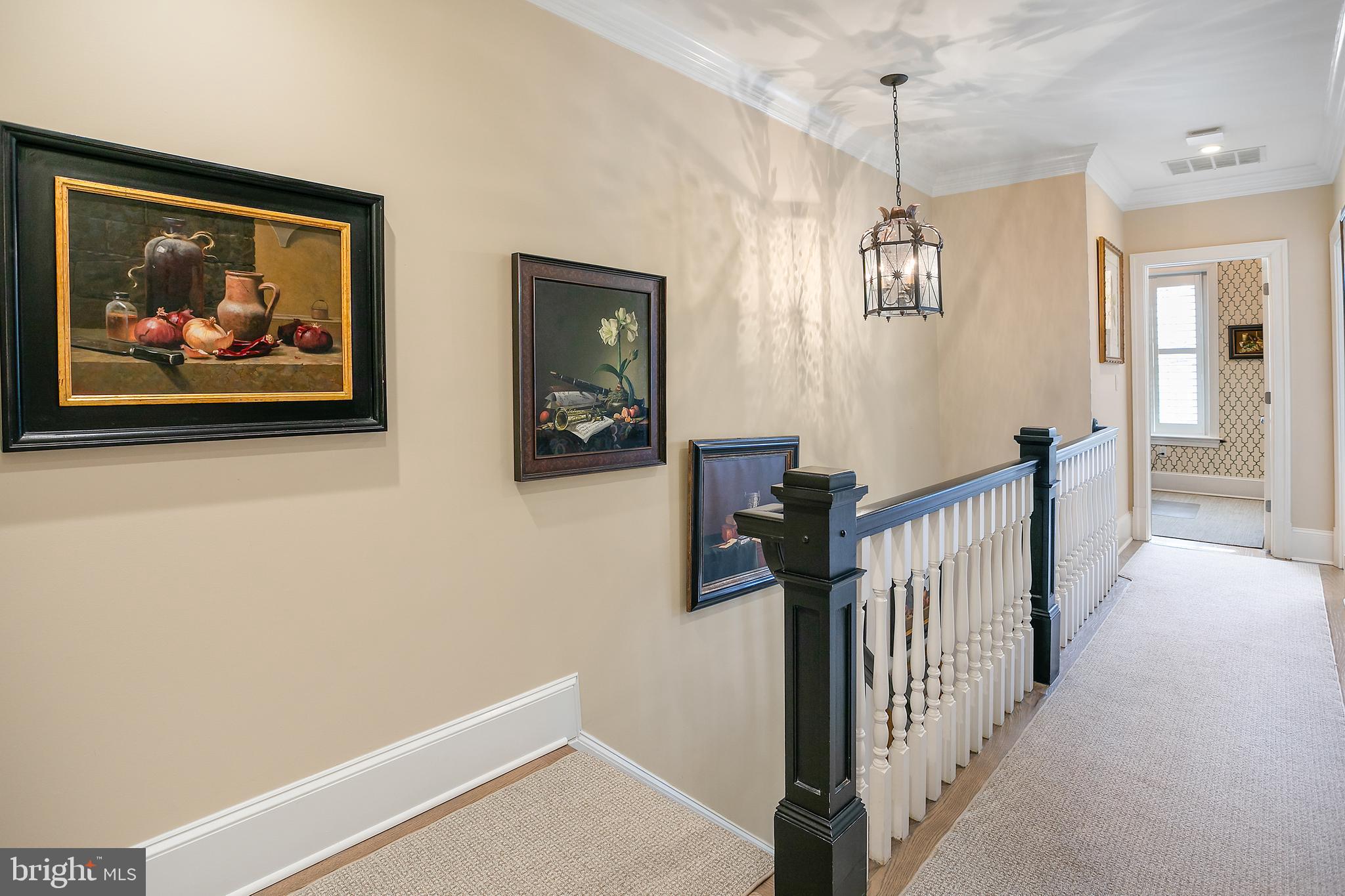 2807 Q Street Northwest Washington, DC 20007 - Photo 14 of 34 a view of a hallway with paintings on the wall