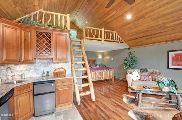 a kitchen with stainless steel appliances a stove a chimney a sink and cabinets