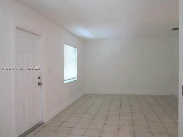 an empty room with white walls and tiles