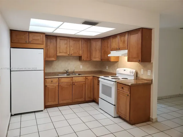 a kitchen with a stove a refrigerator and a sink