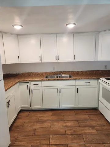 a view of a kitchen with cabinets and wooden floor