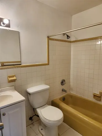 a white toilet and tub sitting next to a bathroom sink