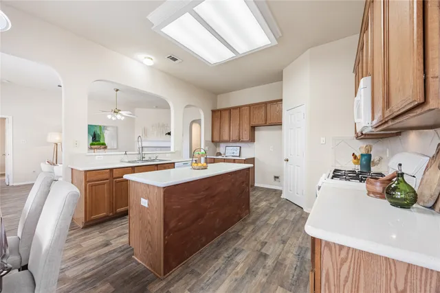 a large kitchen with stainless steel appliances granite countertop a stove and cabinets
