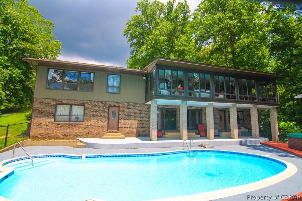 1472 Laurel Point Road Lancaster, VA 22503 - Photo 1 of 40 a view of a house with a swimming pool and porch