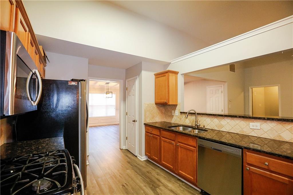 3264 Star Pine Court Duluth, GA 30096 - Photo 15 of 43 a kitchen with stainless steel appliances granite countertop a stove a sink and a refrigerator