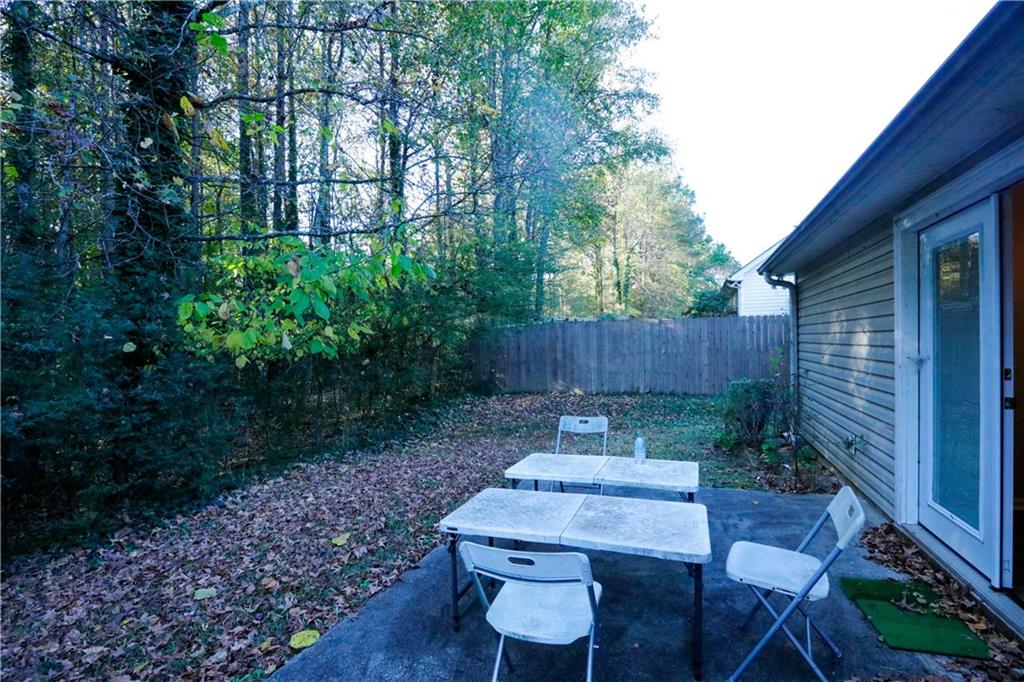 3264 Star Pine Court Duluth, GA 30096 - Photo 43 of 43 a backyard of a house with table and chairs a barbeque with wooden fence