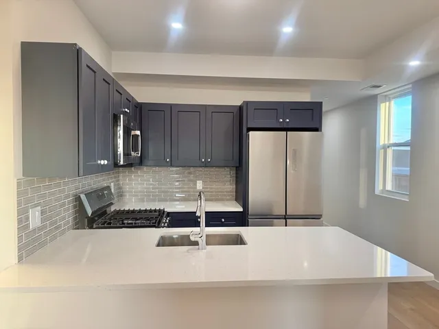 a kitchen with a sink a stove and cabinets