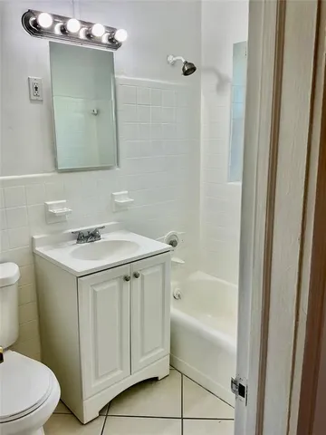 a bathroom with a sink vanity toilet and shower