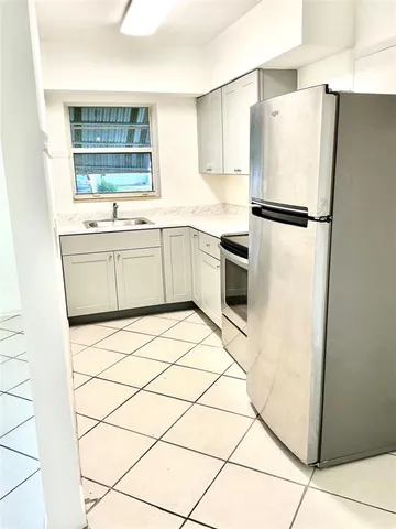 a kitchen with stainless steel appliances a refrigerator sink and cabinets