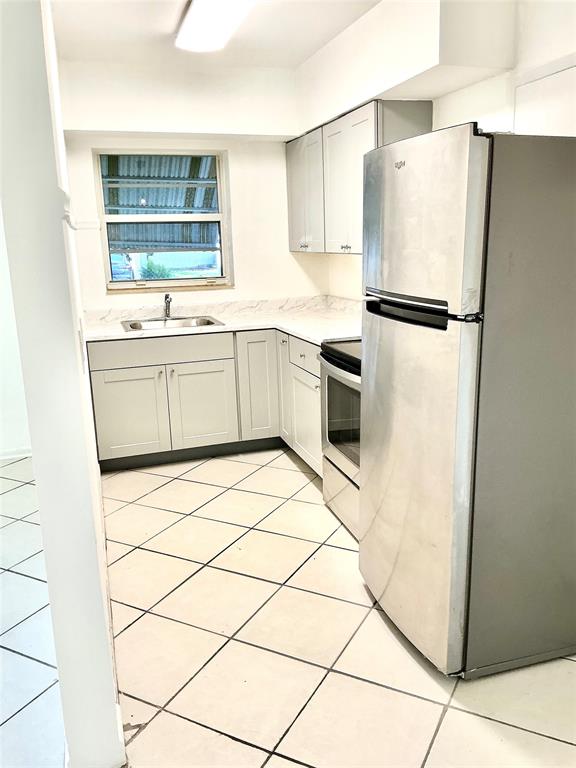1645 Northeast 12th Street, Unit B Fort Lauderdale, FL 33304 - Photo 5 of 20 a kitchen with stainless steel appliances a refrigerator sink and cabinets
