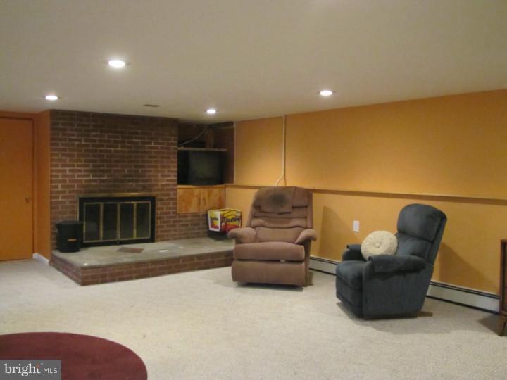 62 Pin Oak Road Skillman, NJ 08558 - Photo 19 of 21 a living room with furniture a fireplace a rug and a kitchen