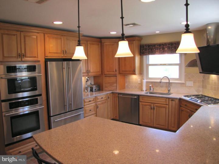 62 Pin Oak Road Skillman, NJ 08558 - Photo 6 of 21 a kitchen with stainless steel appliances granite countertop a refrigerator a sink dishwasher a oven a dining table and chairs with wooden floor