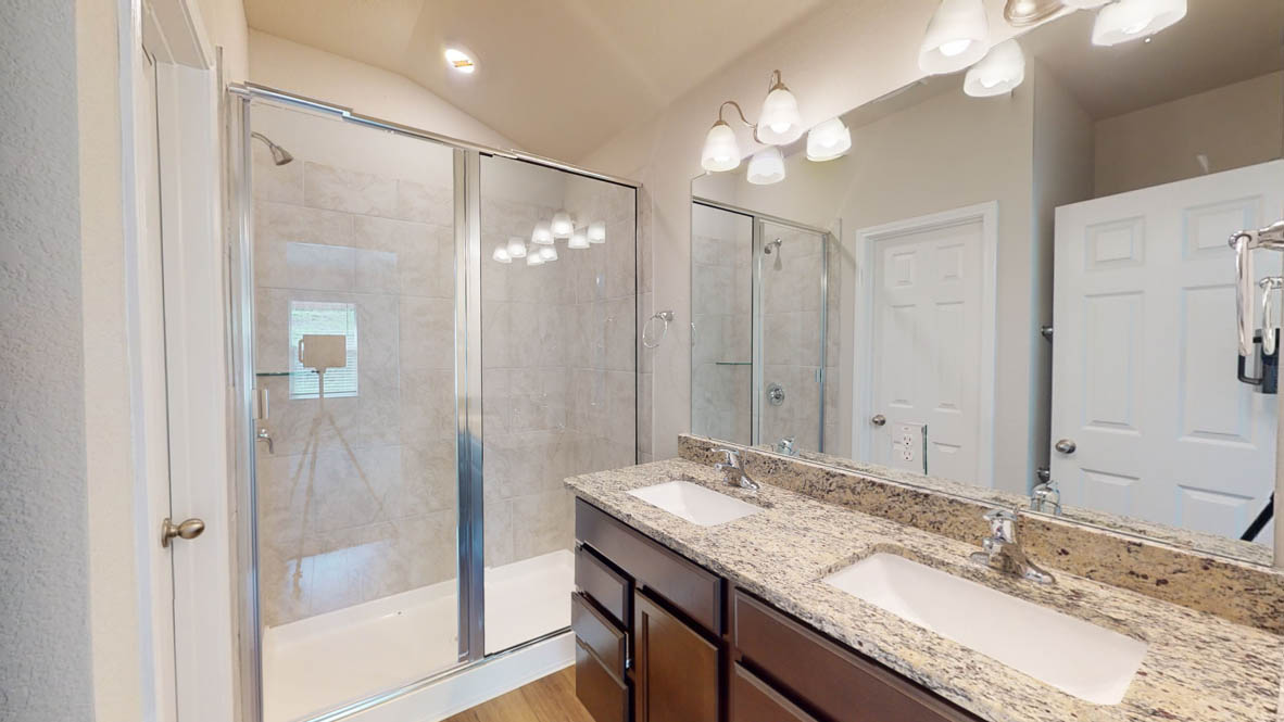 429 Creekfall Road Burnet, TX 78611 - Photo 18 of 28 Granite counters and dual sinks define this elegant, well-appointed bathroom.