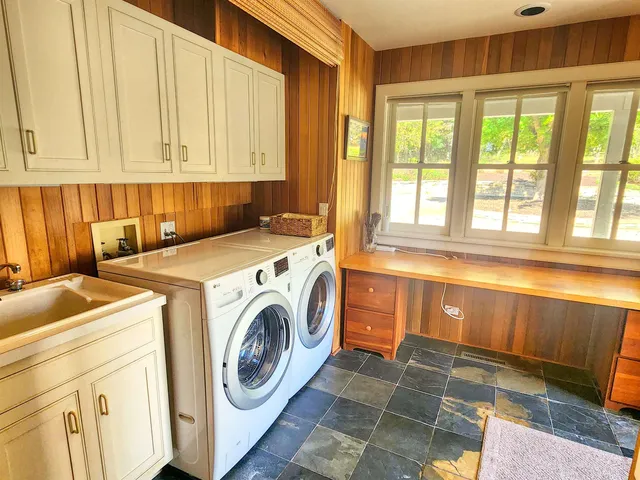 a bath room with a sink and next to a window