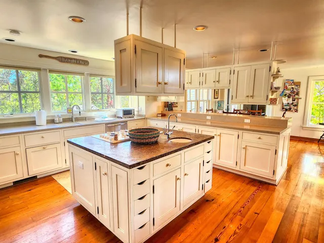 a kitchen with kitchen island granite countertop a stove and a sink