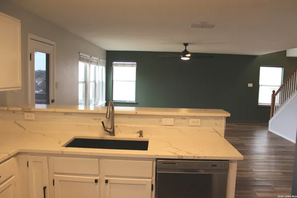 a kitchen with a sink and wooden floor