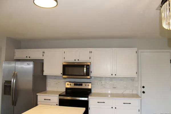 a kitchen with stainless steel appliances a refrigerator a stove a microwave and cabinets