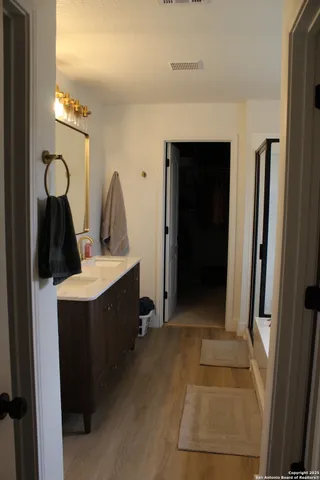 a view of a bathroom with sink mirror and window