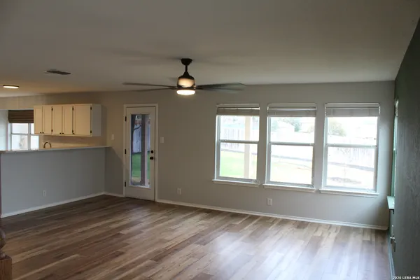 an empty room with wooden floor and windows