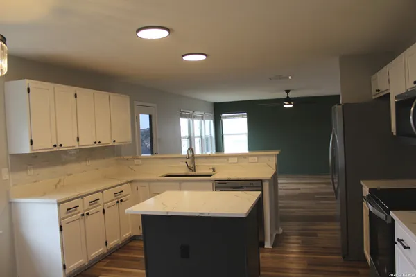 a kitchen with stainless steel appliances granite countertop a sink a stove and a refrigerator