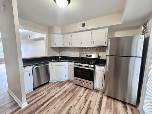 a kitchen with a refrigerator stove and white cabinets
