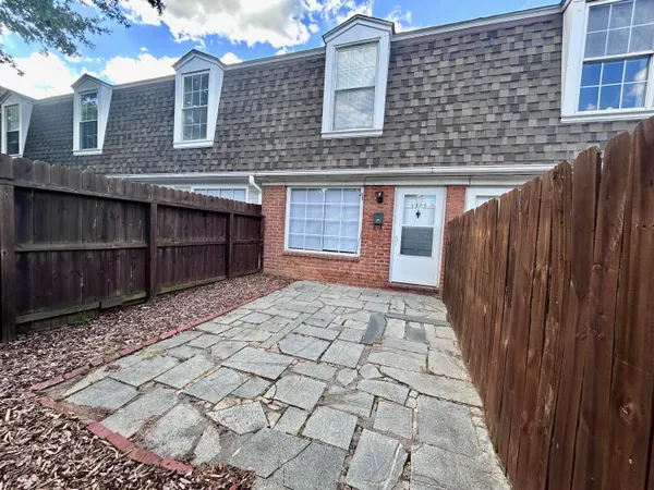 a view of a brick house with wooden fence