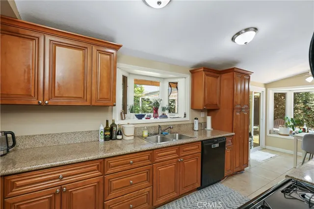 a kitchen with stainless steel appliances granite countertop a sink a stove and cabinets