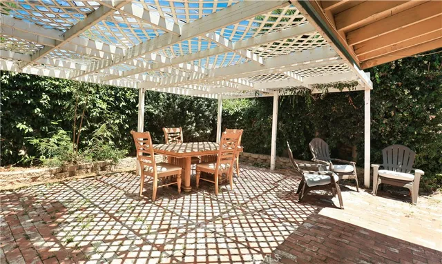 a view of a patio with a dining table and chairs with wooden floor and fence