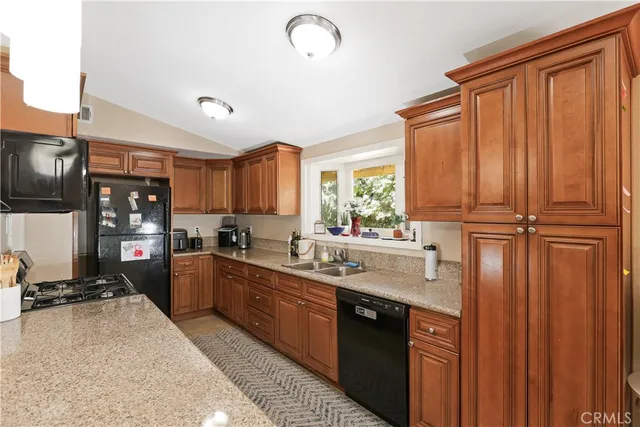 a kitchen with stainless steel appliances granite countertop a sink a stove and a refrigerator
