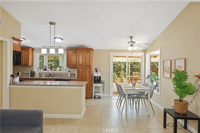 a kitchen with kitchen island granite countertop wooden cabinets and dining table