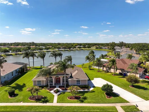 an aerial view of a house with a garden and lake view
