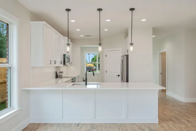 a kitchen with stainless steel appliances a stove a sink and a refrigerator