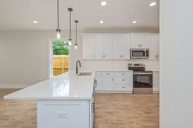 a kitchen with white cabinets and stainless steel appliances