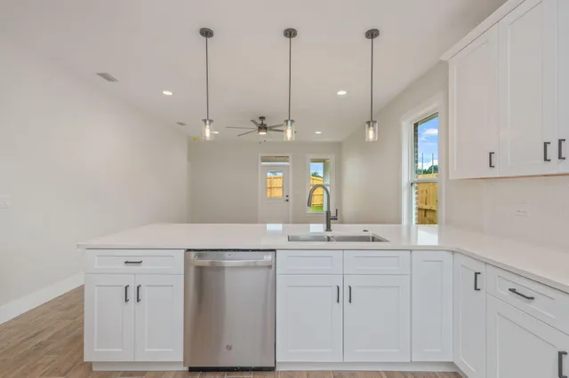 a view of cabinets with stainless steel appliances wooden floor and window