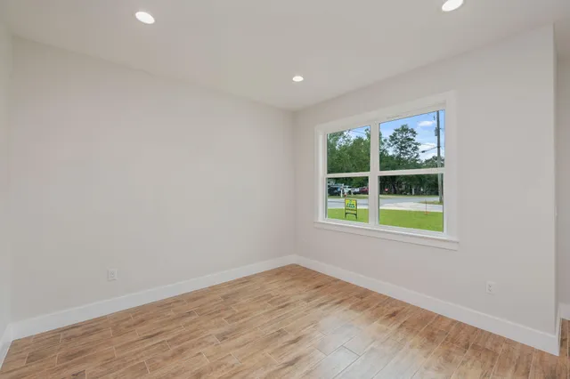 an empty room with wooden floor and a bathroom