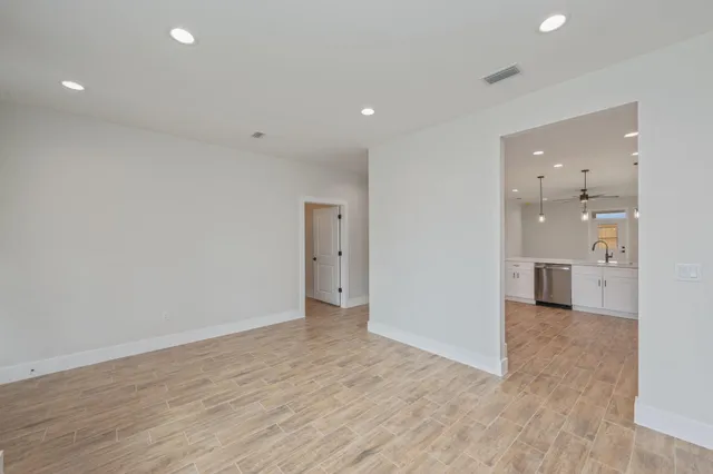 an empty room with windows and fan