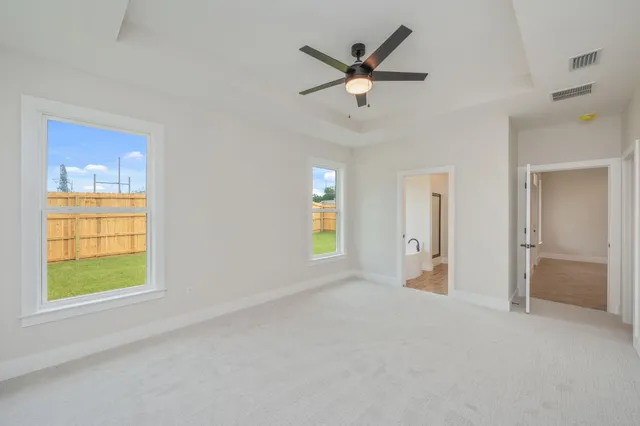 an empty room with a ceiling fan and a window