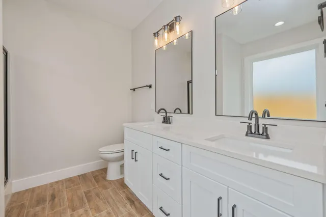 a bathroom with double sink and a mirror