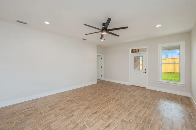 a large white kitchen with kitchen island a sink stainless steel appliances and cabinets