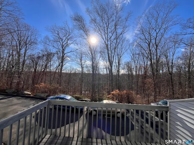 a view of deck with furniture and trees