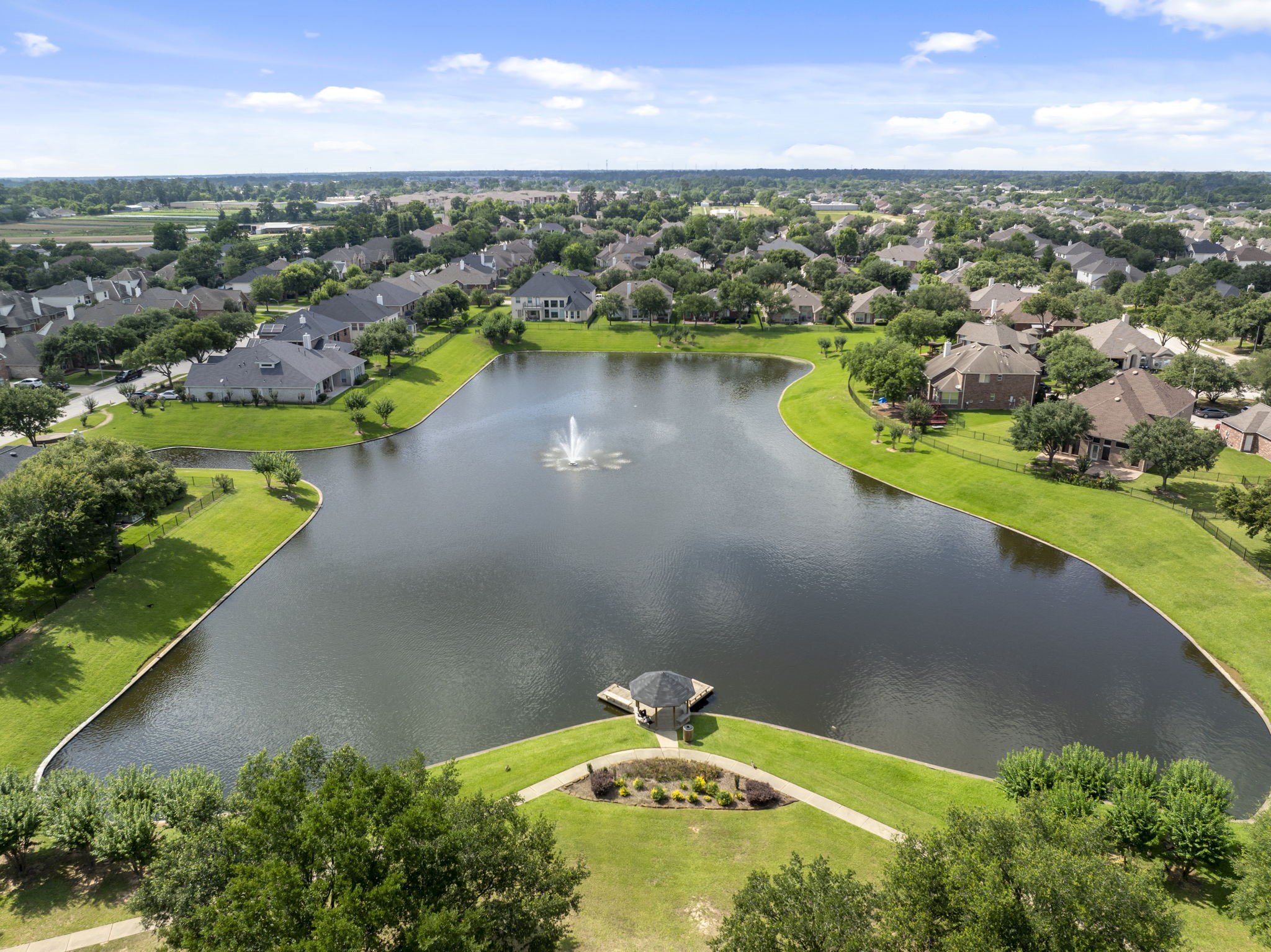 2907 Stemwood Drive Spring, TX 77388 - Photo 3 of 33 Aerial community view showcasing the scenic lake, neighborhood green space, walking paths, and fountain feature that create a peaceful waterfront setting within the community.