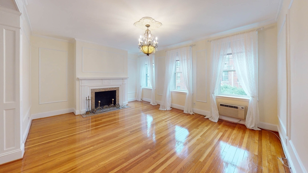 311 Tappan Street, Unit 3 Brookline, MA 02445 - Photo 5 of 35 a view of an empty room with wooden floor fireplace and a window