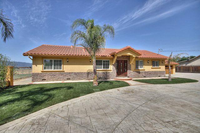 a front view of a house with a garden and yard
