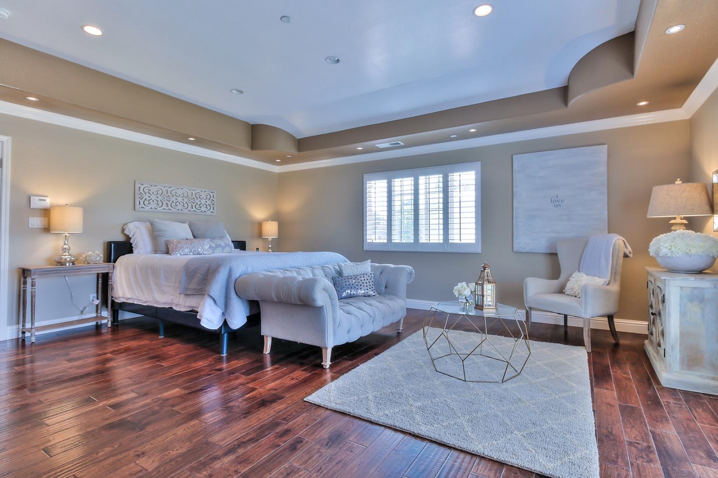 10415 New Avenue Gilroy, CA 95020 - Photo 18 of 55 a spacious bedroom with a bed a table and wooden floor