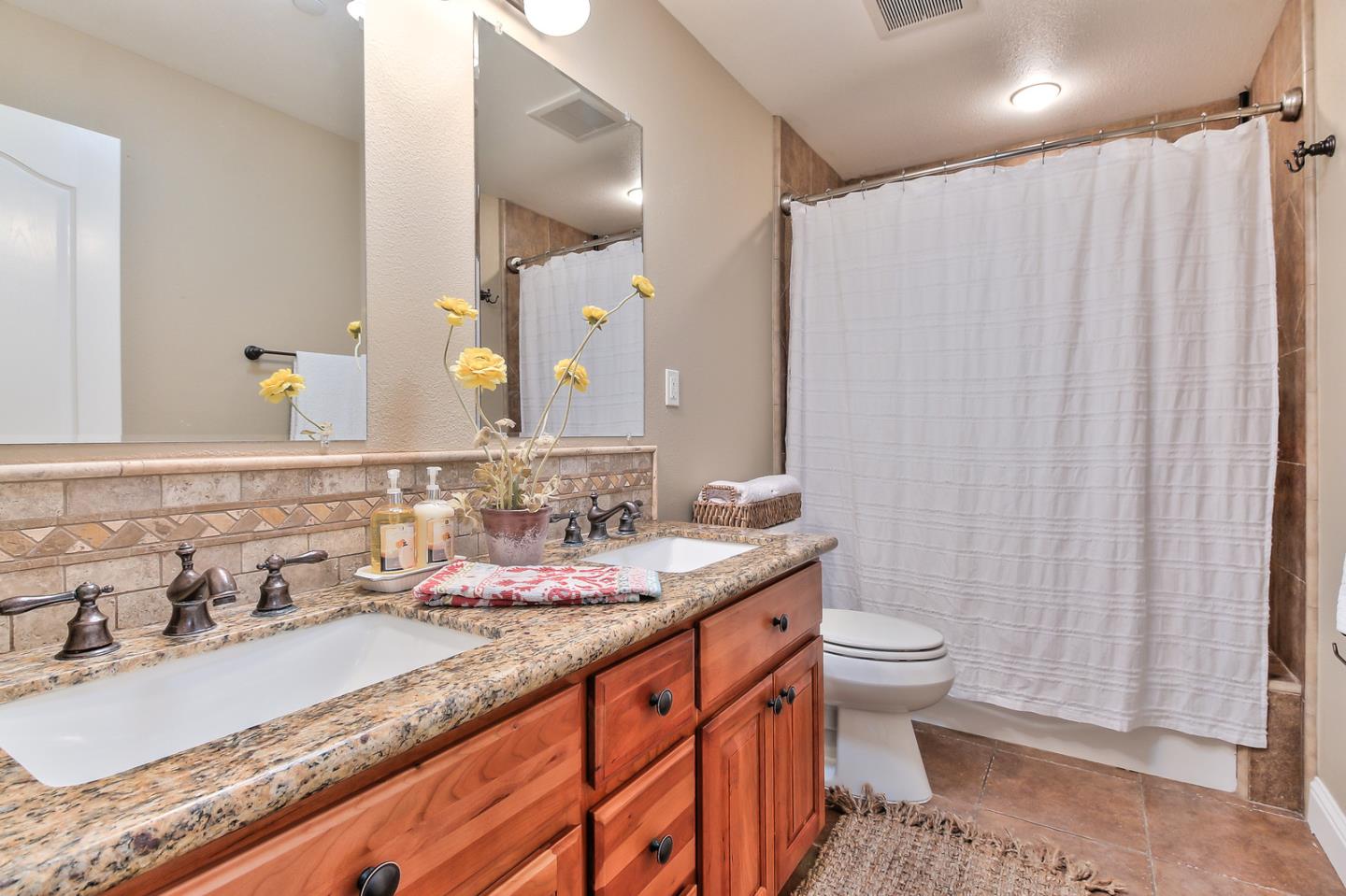 10415 New Avenue Gilroy, CA 95020 - Photo 25 of 55 a bathroom with a granite countertop sink and a mirror